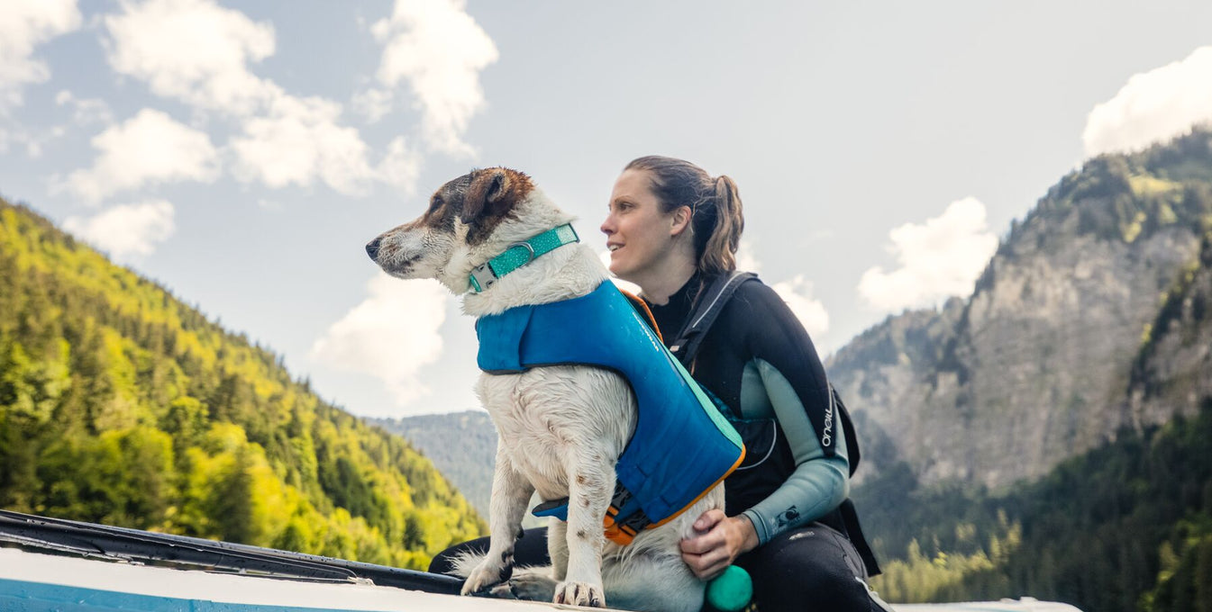 Woman sitting on a paddleboard with her dog.